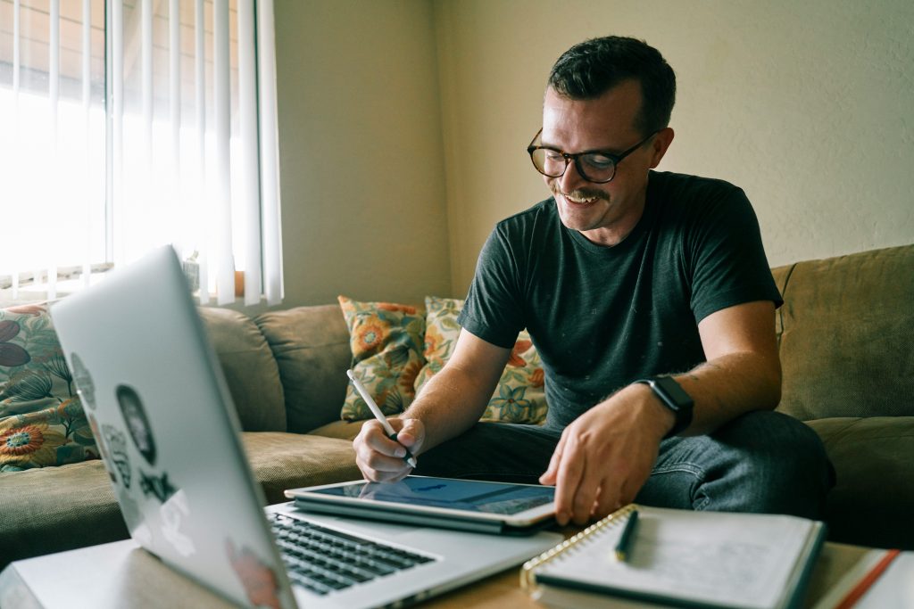 Homem trabalha do sofá de casa/Man works from the couch at home